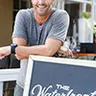 Owner Jason Suzor standing in front of the restaurant's sidewalk sign